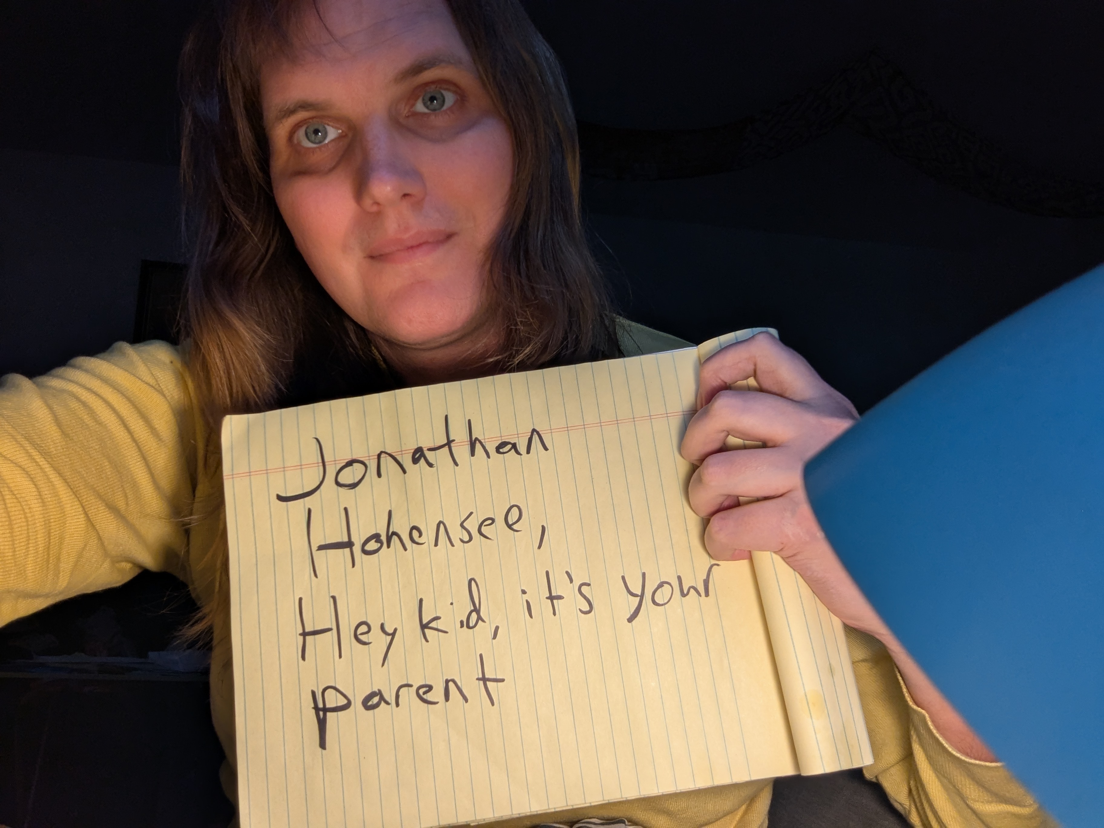 Jonathan Hohensee holding a sign saying hello to his son